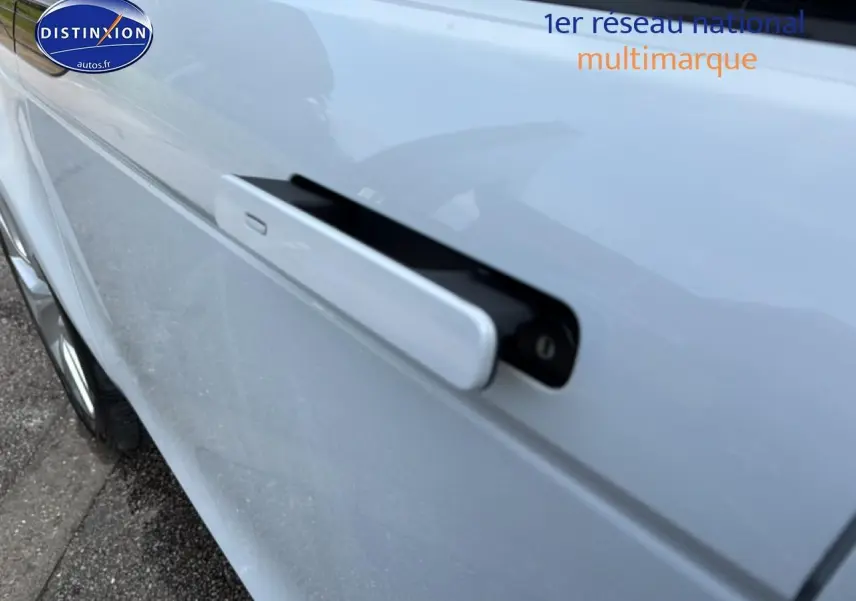 Gros plan sur la poignée de porte rétractable côté gauche d’un Range Rover Evoque blanc et noir.