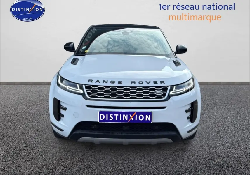 Vue avant d'un Range Rover Evoque blanc avec toit noir, calandre hexagonale et phares LED allumés.