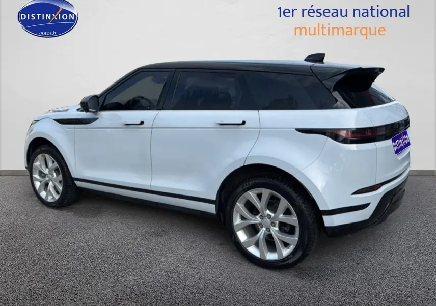 Vue de profil droit d’un Range Rover Evoque blanc avec toit noir et jantes alliage, arrière légèrement visible.