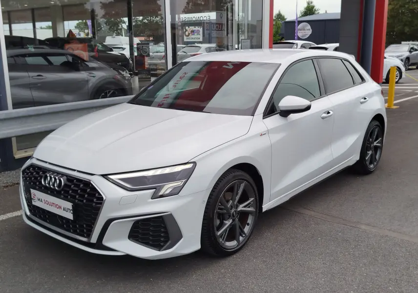 Audi A3 Sportback blanc Glacier métallisé vue 3/4 avant droit avec jantes alliage et calandre S line.