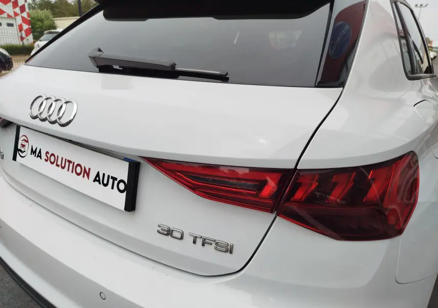Vue arrière droite d'une Audi A3 Sportback blanche Glacier métallisé avec logo et badge 30 TFSI visibles.