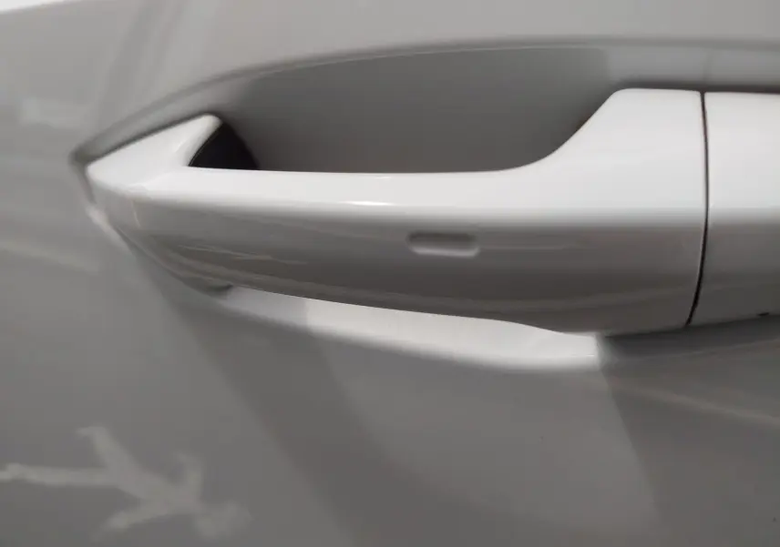 Poignée de porte blanche Glacier métallisé en gros plan sur une Audi A3 Sportback 30 TFSI hybride léger.