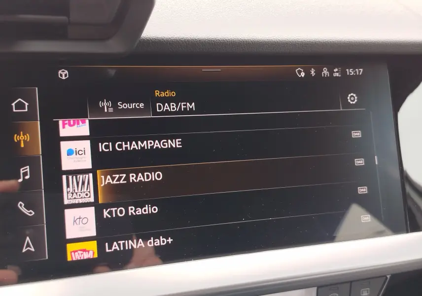 Écran tactile intérieur de l’Audi A3 Sportback 2022 affichant la liste des radios DAB/FM, vue de face.