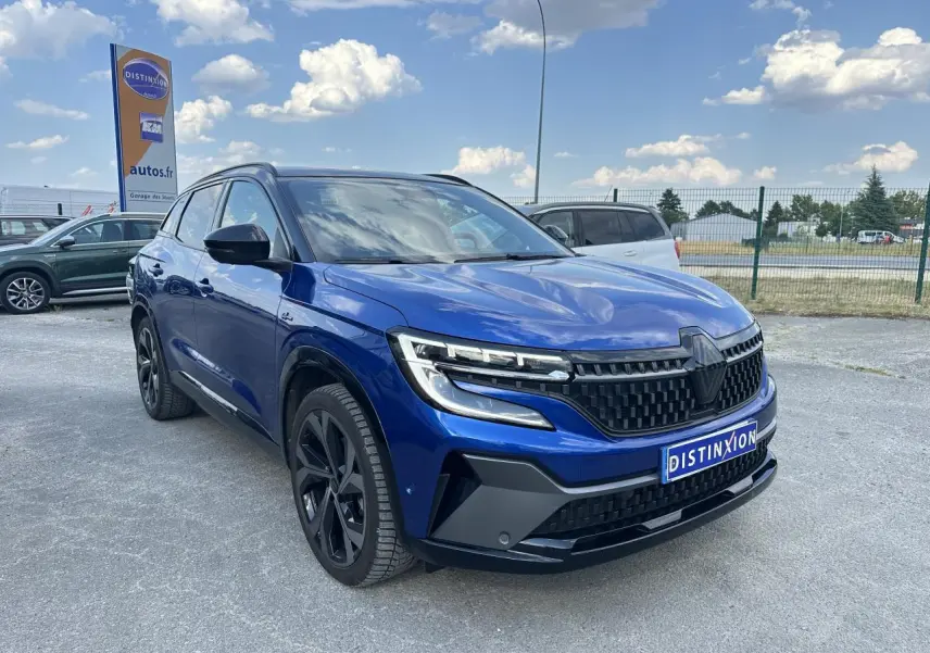 Renault Austral 2024 bleu avec toit noir, vue 3/4 avant mettant en valeur la calandre et les phares LED distinctifs.