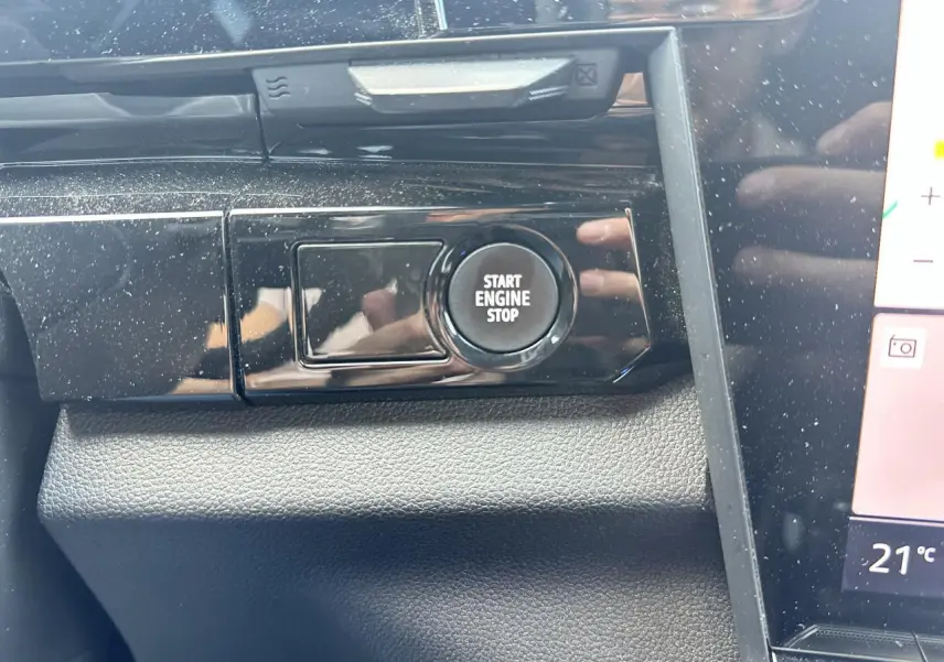 Gros plan sur le bouton Start Engine Stop du tableau de bord noir brillant du Renault Austral 2024 hybride.
