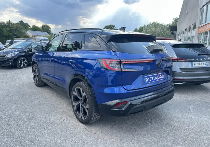 Vue 3/4 arrière droite du Renault Austral hybride bleu avec toit noir et feux arrière LED à effet 3D.