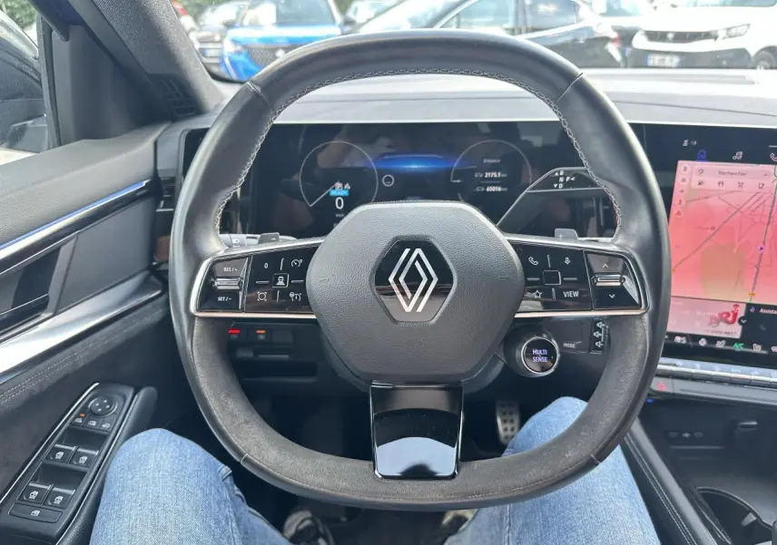Vue intérieure centrée sur le volant multifonction noir du Renault Austral 2024 avec tableau de bord numérique et écran tactile.