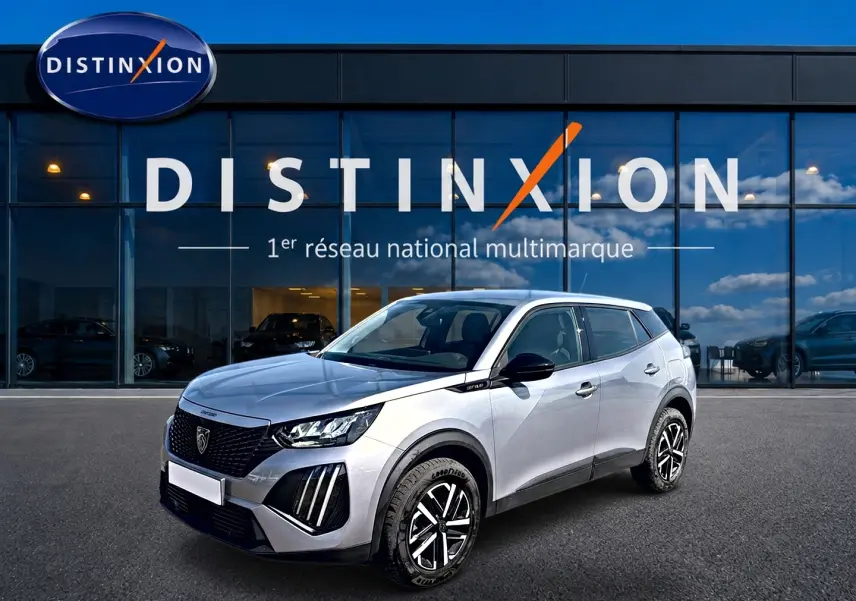 Peugeot 2008 gris en 3/4 avant droit, avec jantes noires et détails noirs sur les rétroviseurs et calandre.