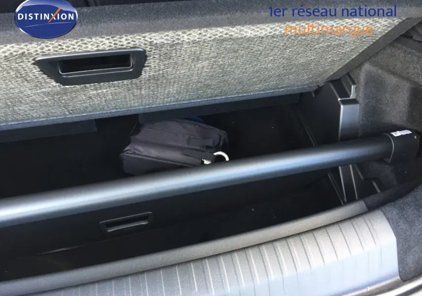 Coffre ouvert du Peugeot 5008 blanc Okenite Metal, montrant le rangement sous plancher avec une trousse noire.