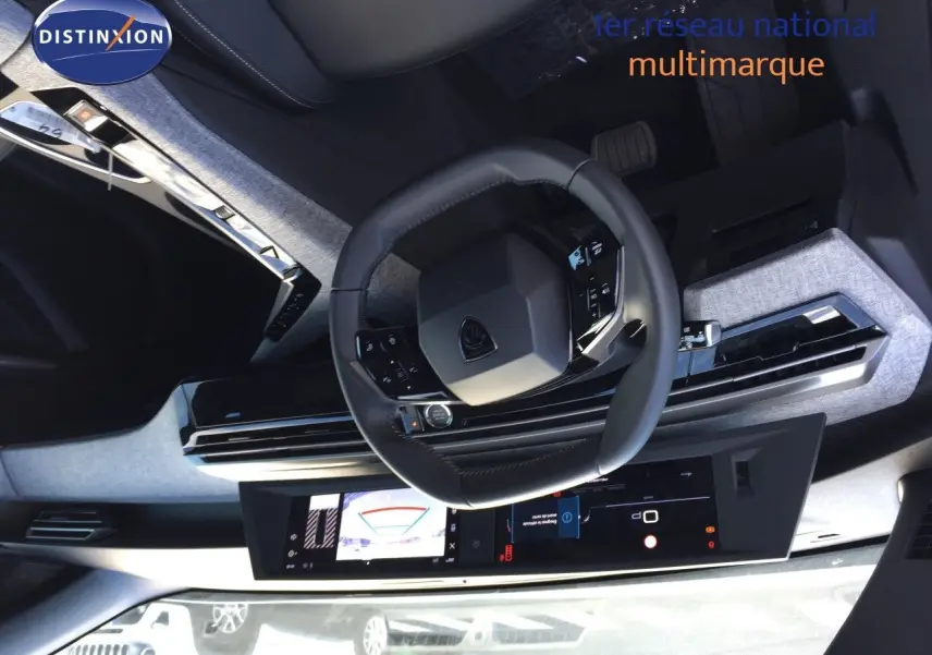 Vue intérieure du tableau de bord et volant cuir noir du Peugeot 5008 Hybrid 2025 avec écran numérique large.