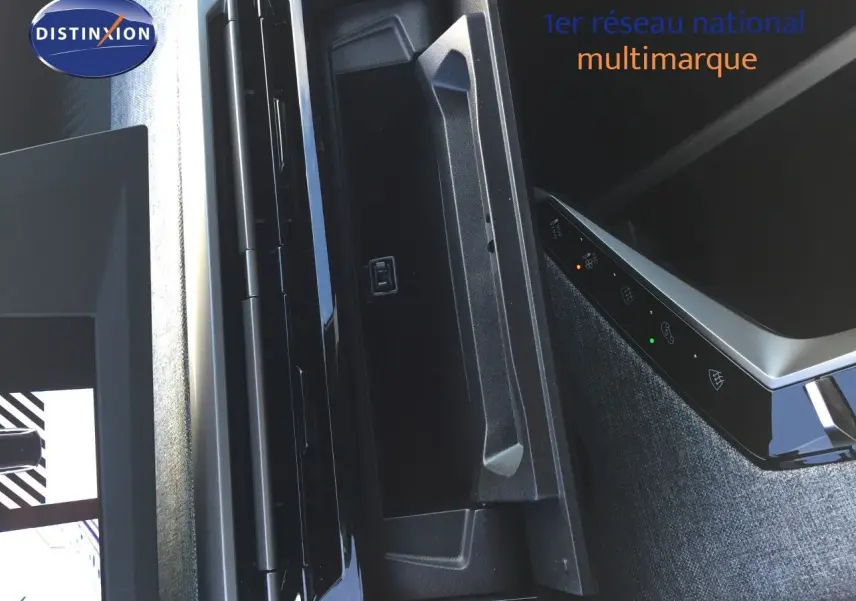 Vue rapprochée de la console centrale noire et grise du Peugeot 5008 Hybrid 2025 avec commandes tactiles éclairées.