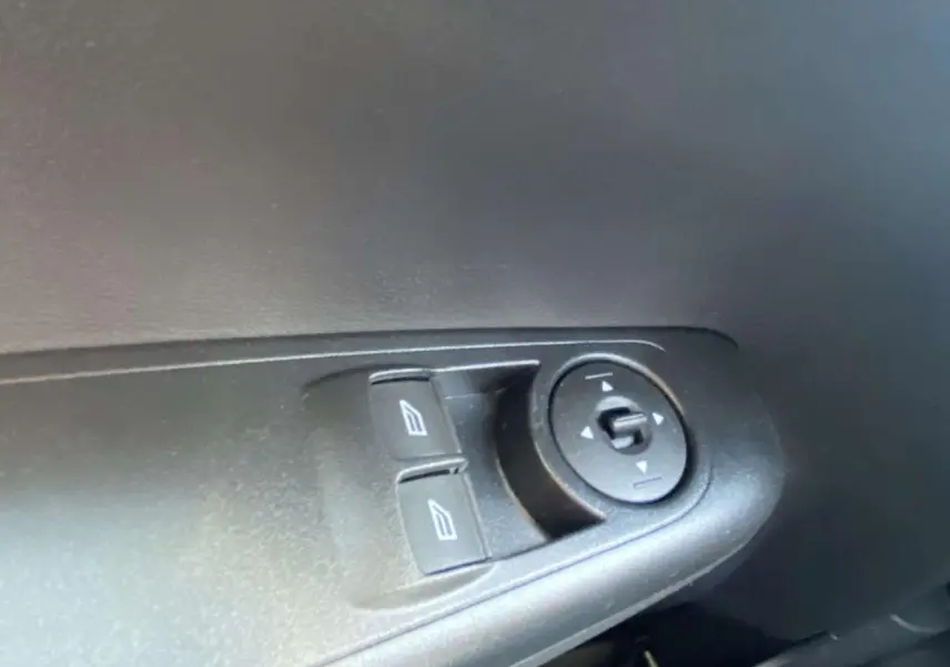 Gros plan sur les commandes électriques des vitres et rétroviseurs côté gauche intérieur du Ford Tourneo Courier blanc 2022.