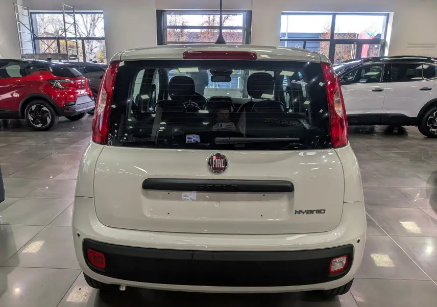 Vue arrière d'une FIAT Panda 1.0 70 CH Hybrid City blanche Gelato en showroom, avec logo et badge Hybrid visibles.