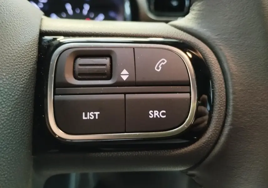 Gros plan sur les commandes audio au volant de la Citroën C3 2024, finition noire avec contour chromé.