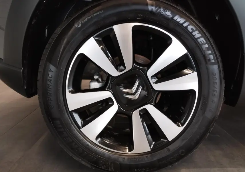 Gros plan sur la jante alliage 16 pouces diamantée noire et argentée d'une Citroën C3 gris foncé.