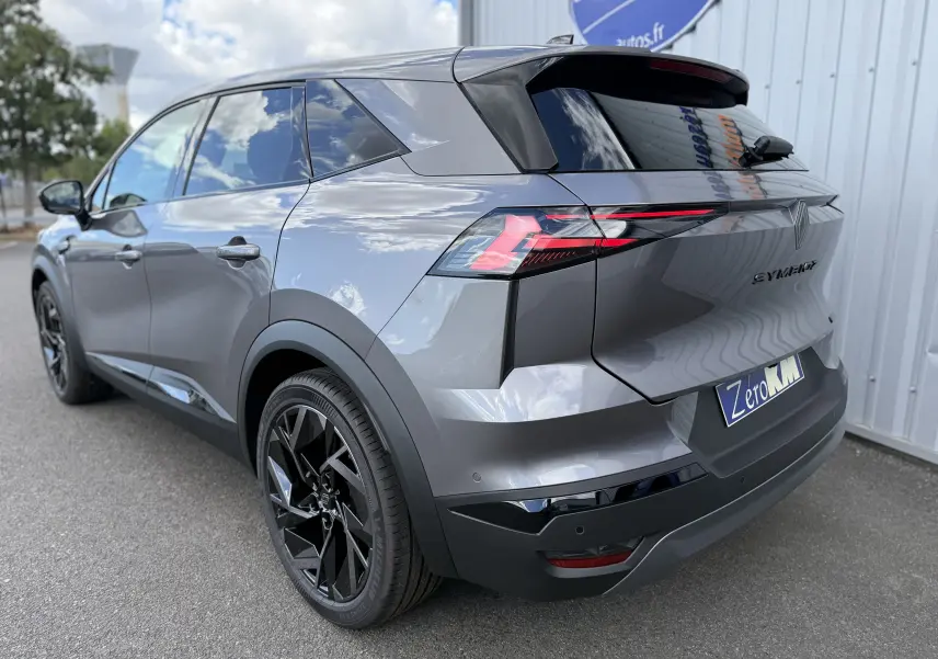 Vue 3/4 arrière droite d’un Renault Symbioz gris cassiopée métal avec feux arrière LED et jantes noires.