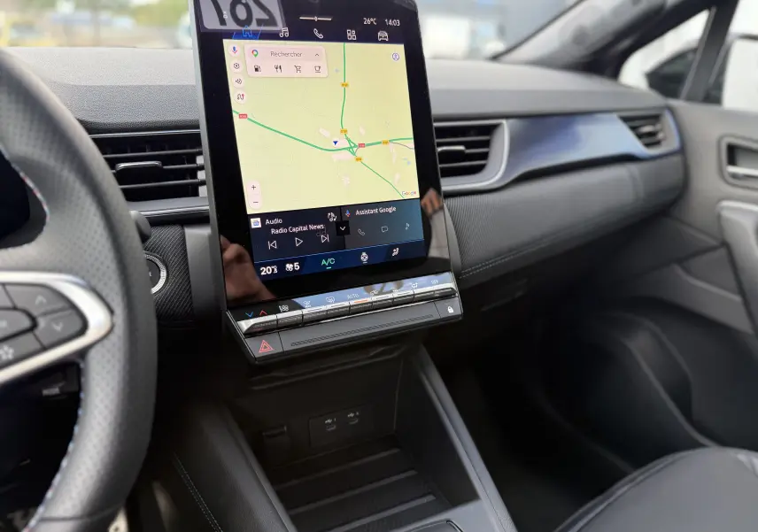 Vue intérieure du tableau de bord de la Renault Symbioz gris cassiopée, avec écran tactile vertical affichant la navigation.