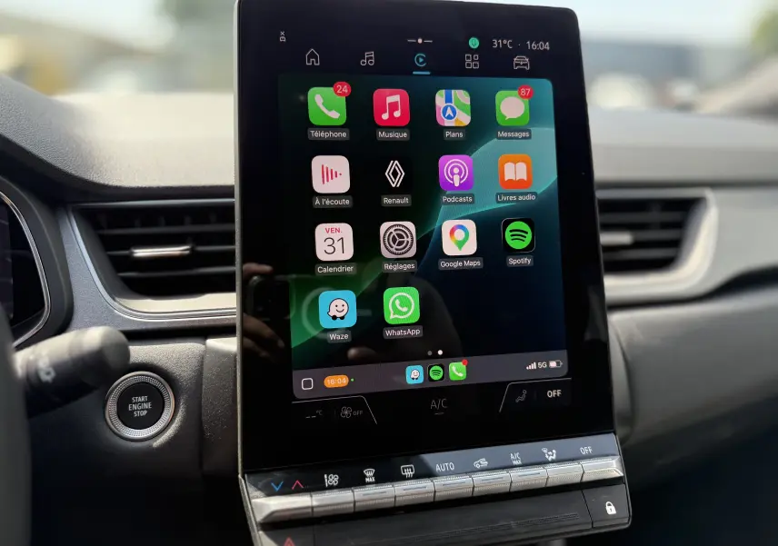 Gros plan sur l'écran tactile central du Renault Captur 2025, affichant les applications connectées dans un intérieur moderne.