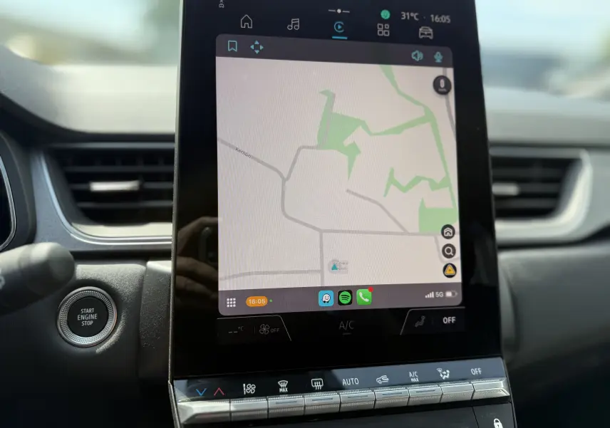 Vue rapprochée de l’écran tactile central et du bouton start/stop du tableau de bord du Renault Captur gris Rafale toit noir.