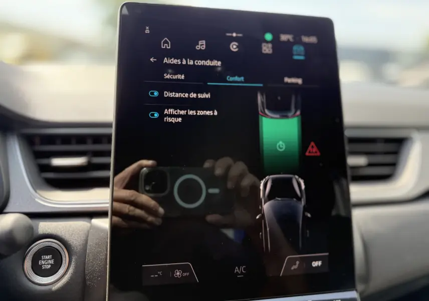 Écran tactile central du Renault Captur 2025 montrant les aides à la conduite, intérieur avec bouton start/stop visible.