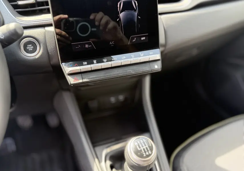 Vue rapprochée de la console centrale du Renault Captur 2025 avec levier de vitesses manuel et écran tactile noir.