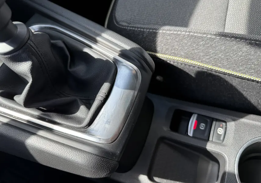 Gros plan sur la console centrale du Renault Captur 2025, montrant le levier de vitesse manuel et le frein à main électronique.