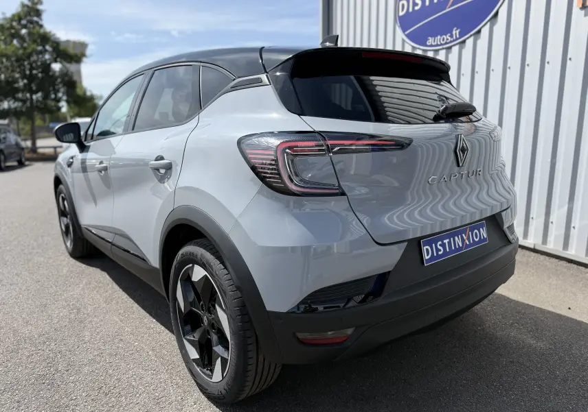 Vue 3/4 arrière droite du Renault Captur 2025 gris Rafale avec toit noir et feux arrière LED distinctifs.