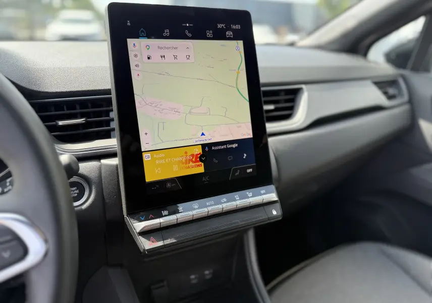 Vue rapprochée de la console centrale du Renault Captur 2025 avec écran tactile vertical affichant la navigation et la radio.