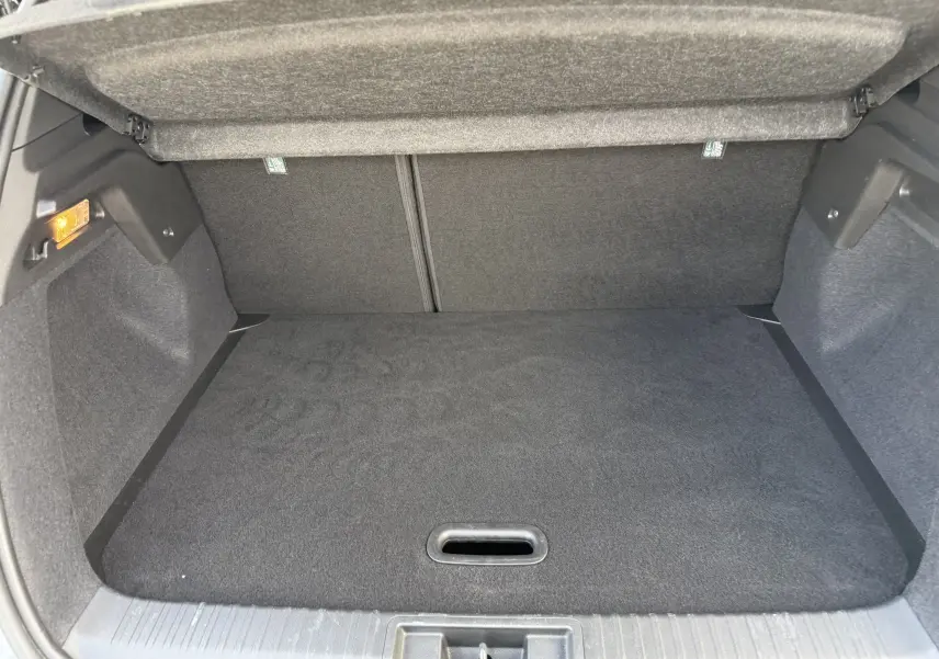 Coffre ouvert d’un Renault Captur 2025 gris Rafale avec toit noir, montrant un espace de rangement vide et propre.
