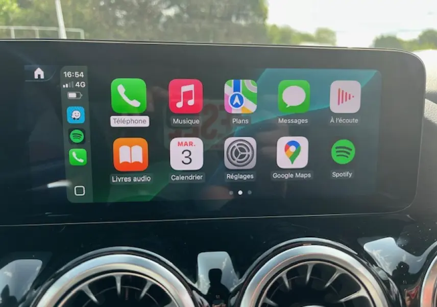 Écran tactile central affichant Apple CarPlay dans l'habitacle d'une Mercedes GLA 250 e blanche 2024.