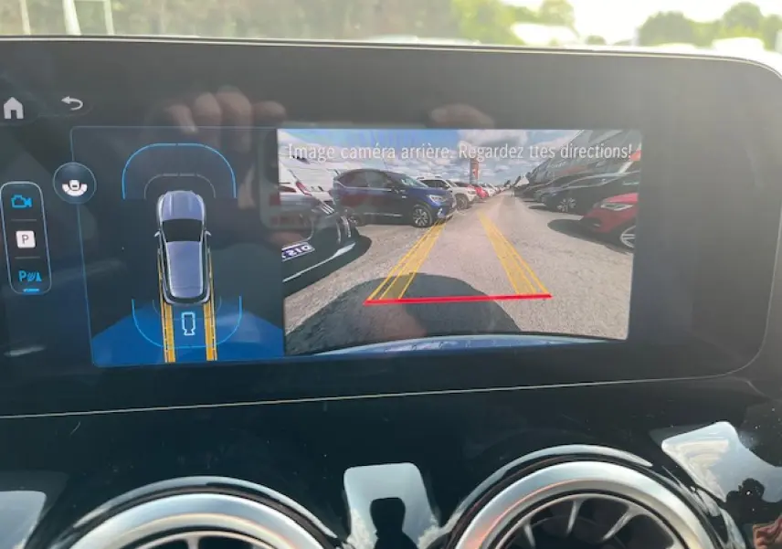 Écran multimédia du Mercedes GLA 250 e blanc 2024 montrant la caméra de recul et l'aide au stationnement