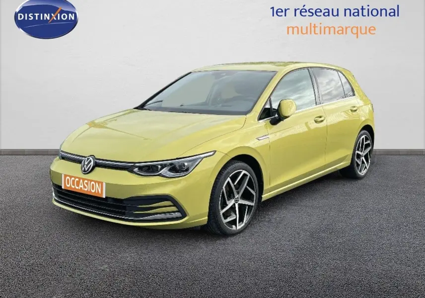 Volkswagen Golf 1.5 eTSI jaune vue 3/4 avant droit sur sol gris devant un mur blanc.