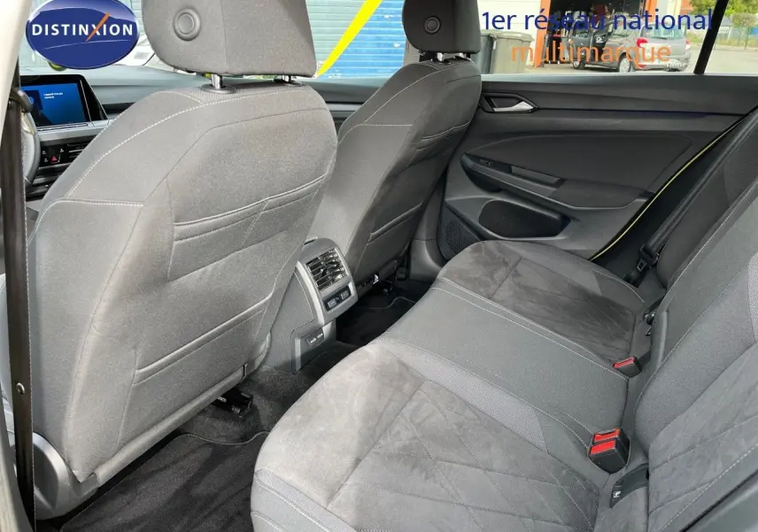 Vue arrière de l'intérieur de la Volkswagen Golf jaune 1.5 eTSI 2020, sièges tissu gris et console centrale avec aérateurs.