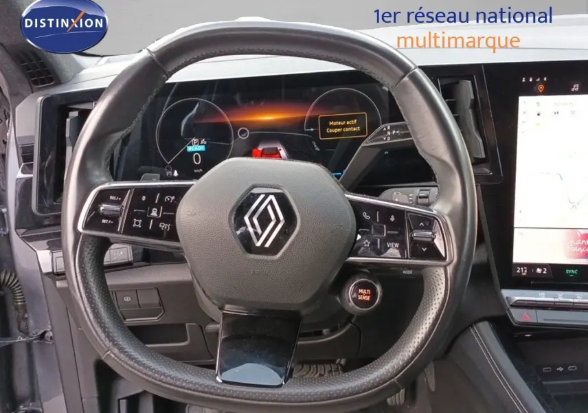 Vue rapprochée du volant cuir du Renault Espace VI hybride 2024 avec tableau de bord numérique et écran tactile.