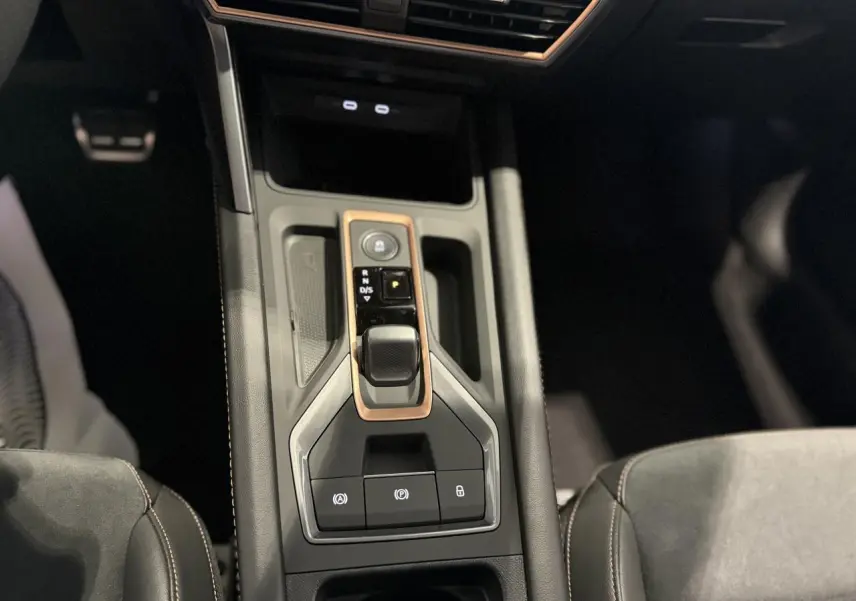 Vue plongeante sur la console centrale noire du CUPRA Formentor avec levier de vitesse DSG et surpiqûres cuivrées.