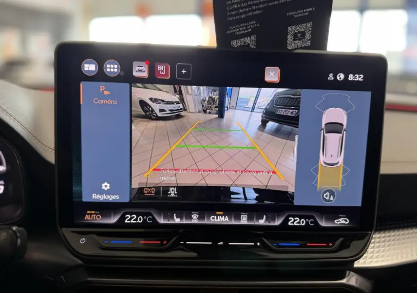 Écran tactile intérieur affichant la caméra de recul du CUPRA Formentor noir Night, vue arrière en parking intérieur.