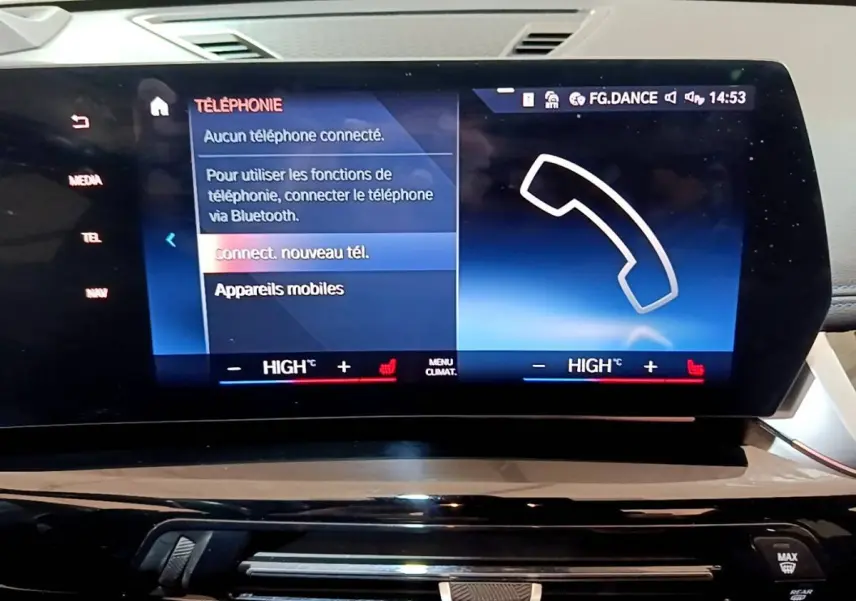 Écran tactile central du tableau de bord du BMW X1 noir, affichant le menu téléphone et réglages climatisation.
