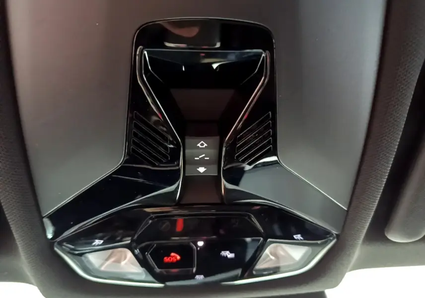 Vue en contre-plongée du plafonnier noir brillant avec boutons SOS et commandes d’éclairage intérieur du BMW X1 2023.
