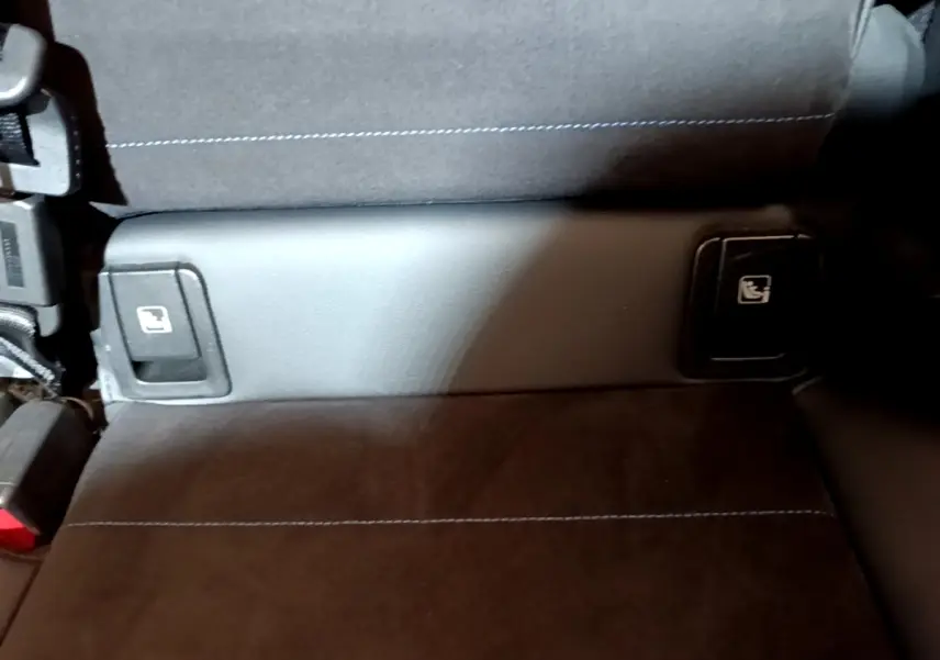 Détail de la banquette arrière noire avec commandes de rabattement des sièges sur une BMW X1 xDrive23i M Sport 2023.