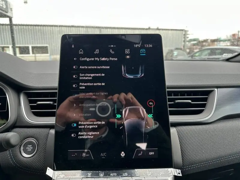 Tablette tactile centrale du Renault Captur 2026 affichant les options de sécurité, entourée de l’habitacle noir.
