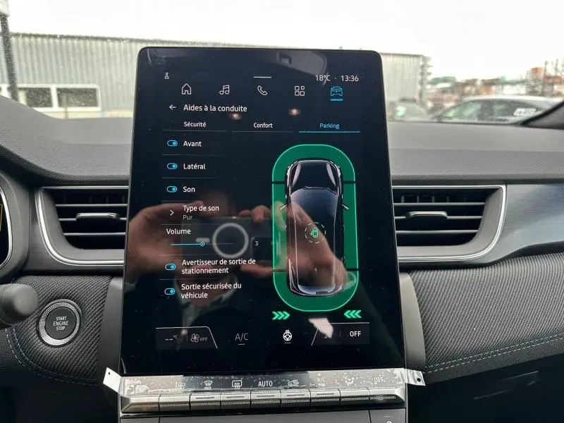 Écran tactile central du Renault Captur 2026 affichant les aides à la conduite, intérieur avec tableau de bord gris et noir.