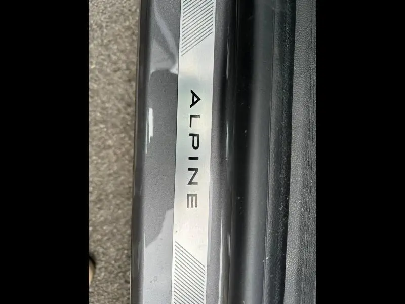 Gros plan sur la plaque de seuil de porte gris Cassiopée avec inscription Alpine du Renault Captur 1.8 E-Tech hybride 2026.