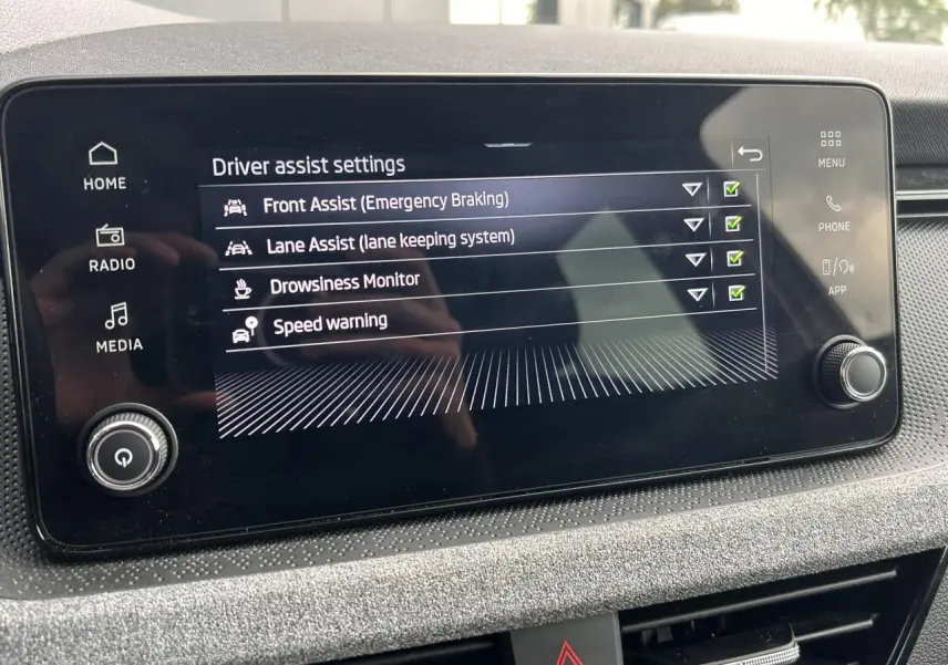 Écran tactile central de la Skoda Scala TSI 116 DSG7 affichant les réglages d’aides à la conduite.