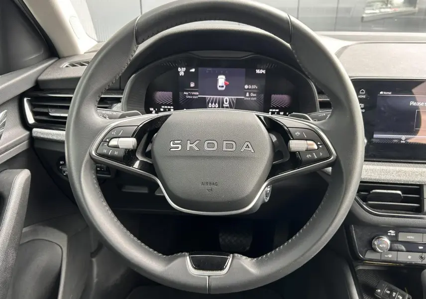 Vue frontale du volant cuir noir multifonctions SKODA dans l'habitacle moderne du SCALA blanc Candy 2025.