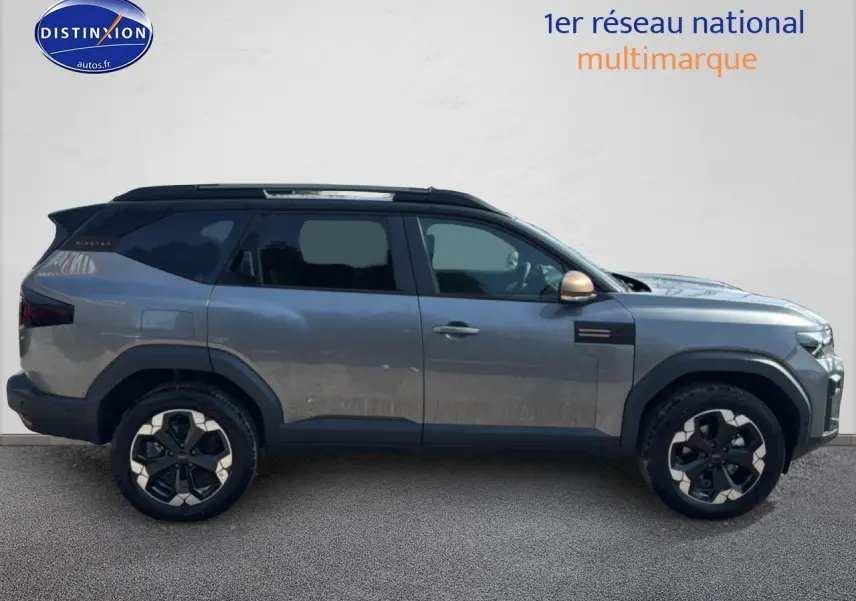 Profil droit du Dacia Bigster gris schiste avec jantes alu noires et toit noir contrasté.