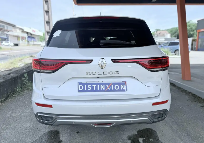Vue arrière d'un Renault Koleos blanc 2021 avec feux arrière étirés et logo au centre du hayon.