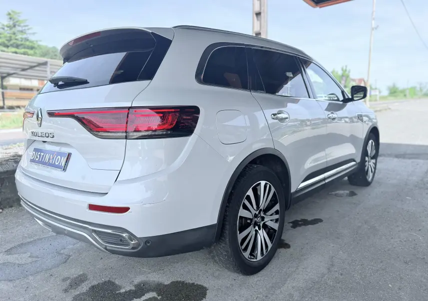 Vue 3/4 arrière droite d'un Renault Koleos blanc avec jantes alliage et feux arrière LED distinctifs.
