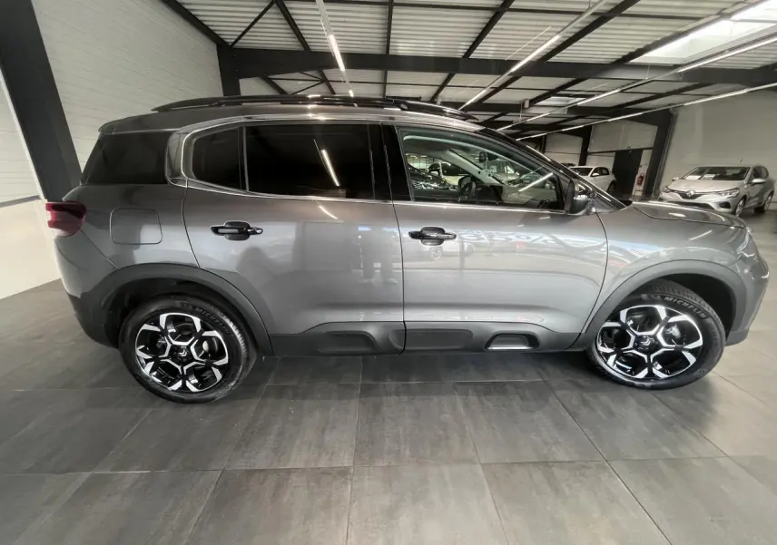 Vue latérale droite d'un Citroën C5 Aircross gris platinium avec jantes alliage bi-ton et vitres surteintées.