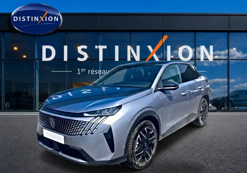 Peugeot 3008 gris en 3/4 avant droit, avec calandre distinctive et jantes alliage noires devant showroom Distinxion.