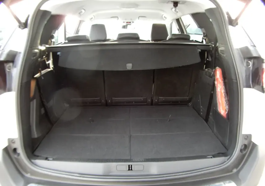 Coffre ouvert du Peugeot 5008 blanc nacré, vue arrière montrant l'espace de chargement et la tablette cache-bagages.